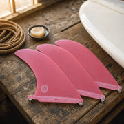 STCo. Classic Pivot Longboard Fin - Red styled on a shaping bench (AI-generated visualization)